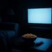 Ruangan gelap dengan TV menyala dan sofa kosong, suasana menonton film horor sendirian